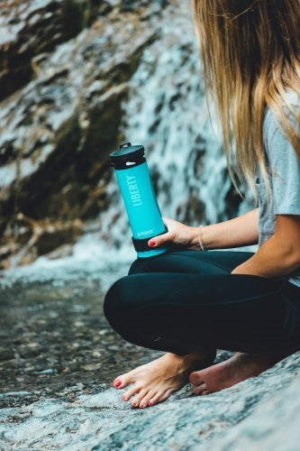 Lifesaver Liberty bleu clair dans la main d'une femme sur un rocher près d'une cascade