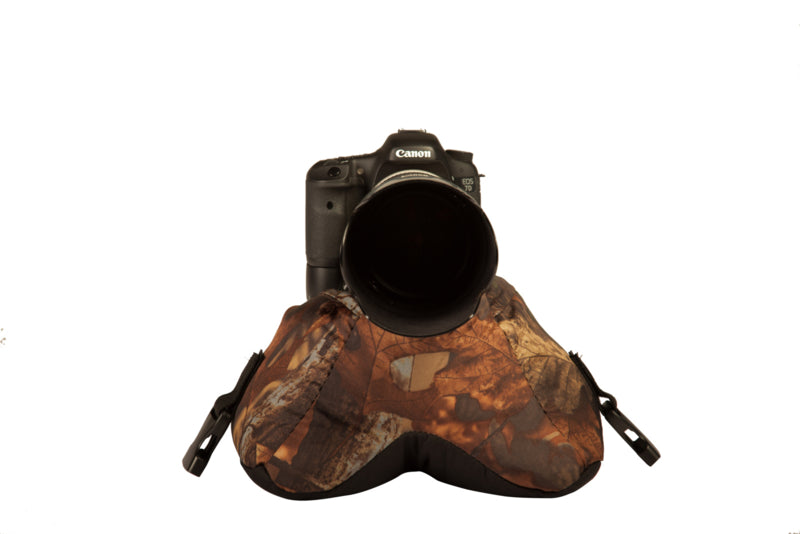 Buteo Photo Gear Bean Bag 1 en camouflage feuillage avec un appareil photo et un téléobjectif dessus, vue de face