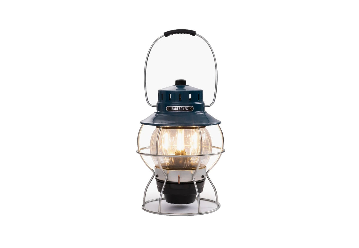 Lampe Barebones Railroad avec capot bleu, allumée avec une lumière chaude derrière le verre