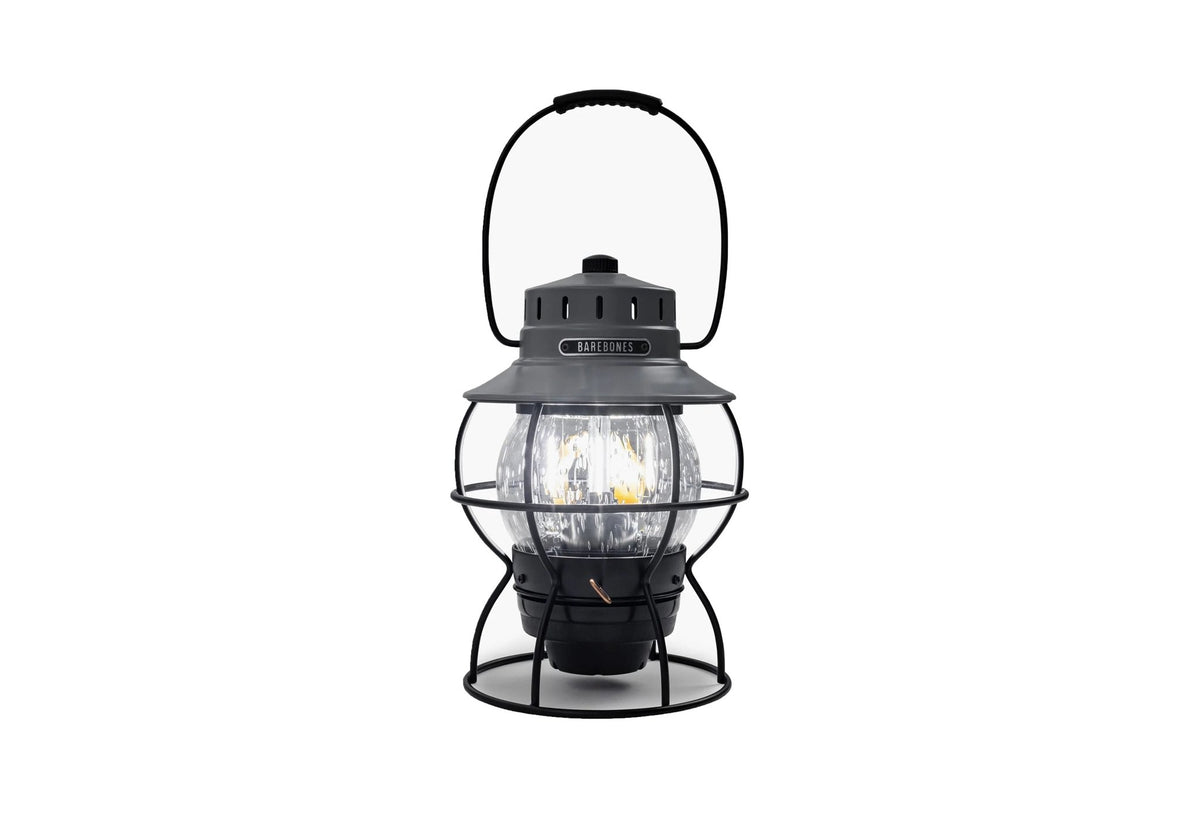 Lampe Barebones Railroad gris foncé, allumée, avec cage en métal et anse de transport