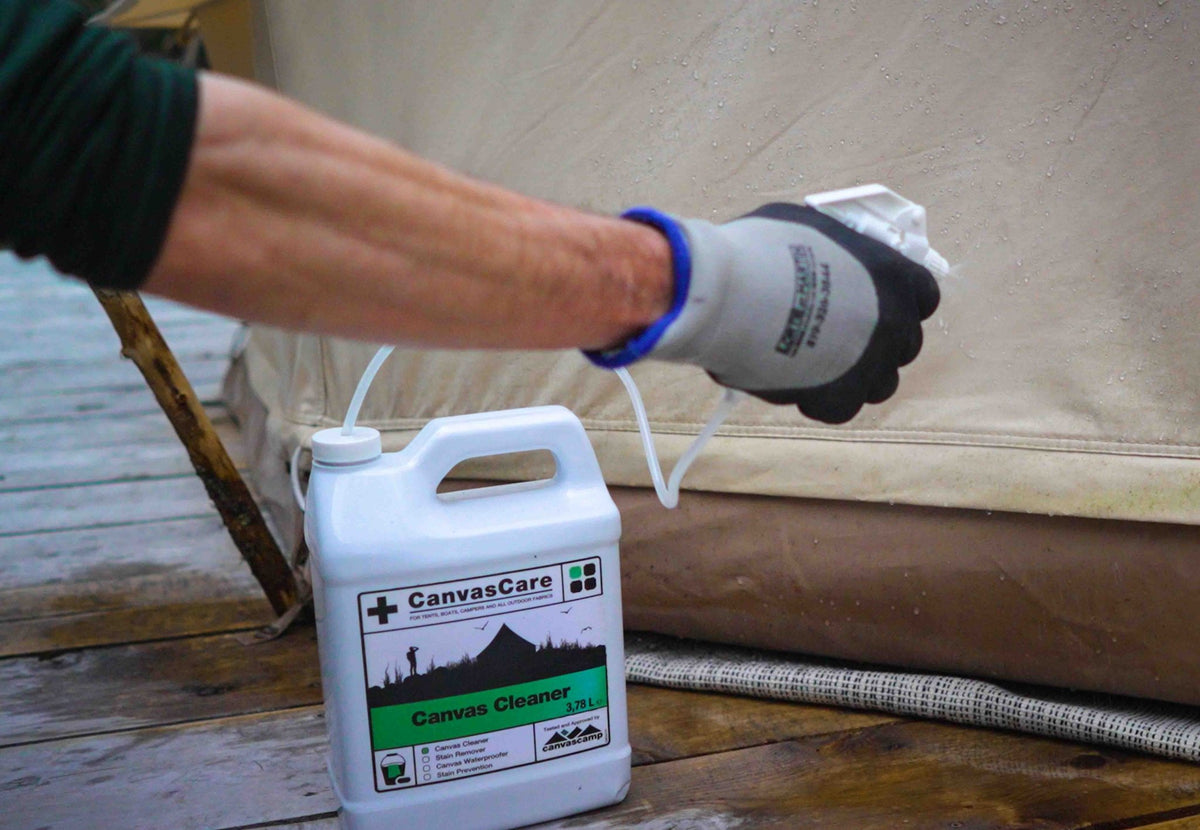 Bouchon de pulvérisation CanvasCare en usage, une personne avec gant de travail pulvérise du nettoyant sur une tente