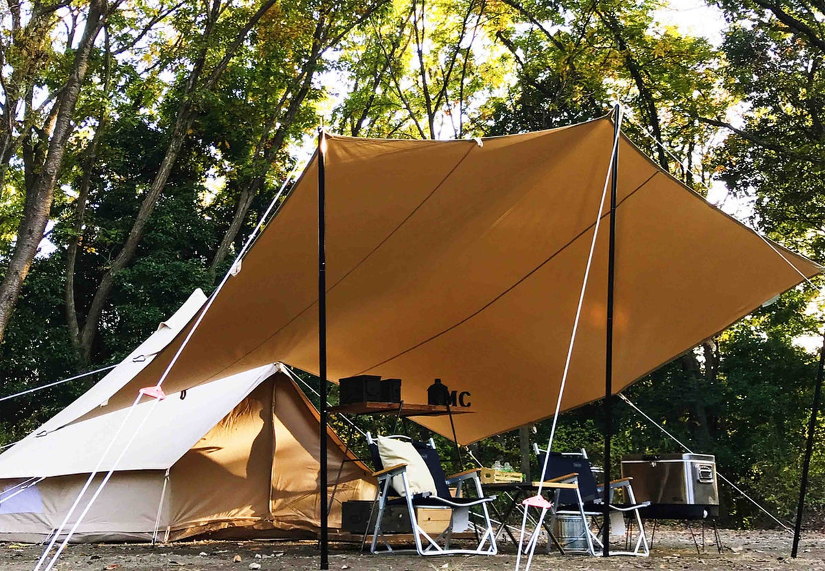 CanvasCamp Classic All Purpose Shelter, bâche ocre sur mâts au-dessus de chaises près d'une tente cloche
