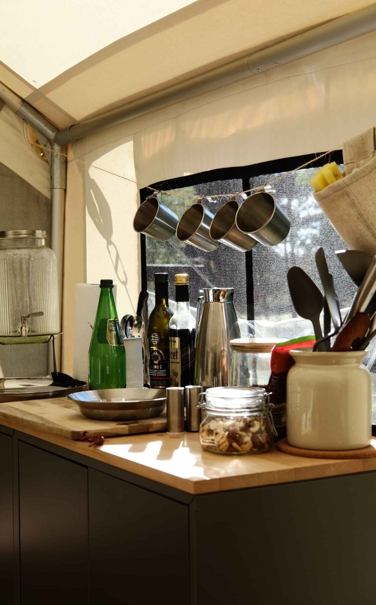 CanvasCamp Heavy Duty Safari Tent aménagée avec un bloc cuisine et des casseroles suspendues devant la fenêtre