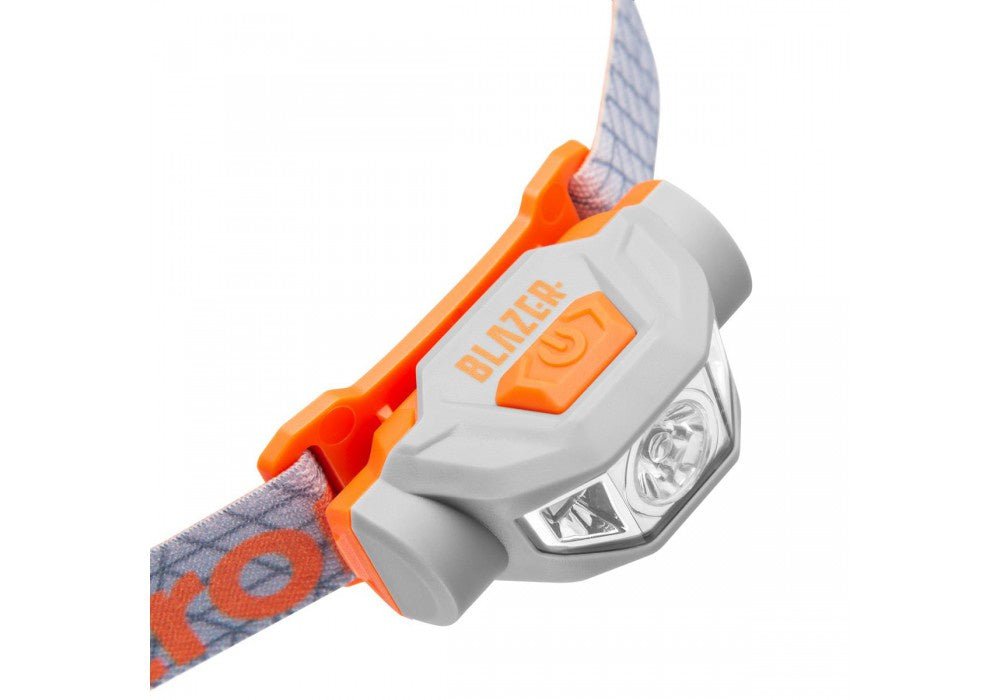 Lampe frontale Mactronic Blazer de profil avec le bouton orange et les lentilles à l'avant
