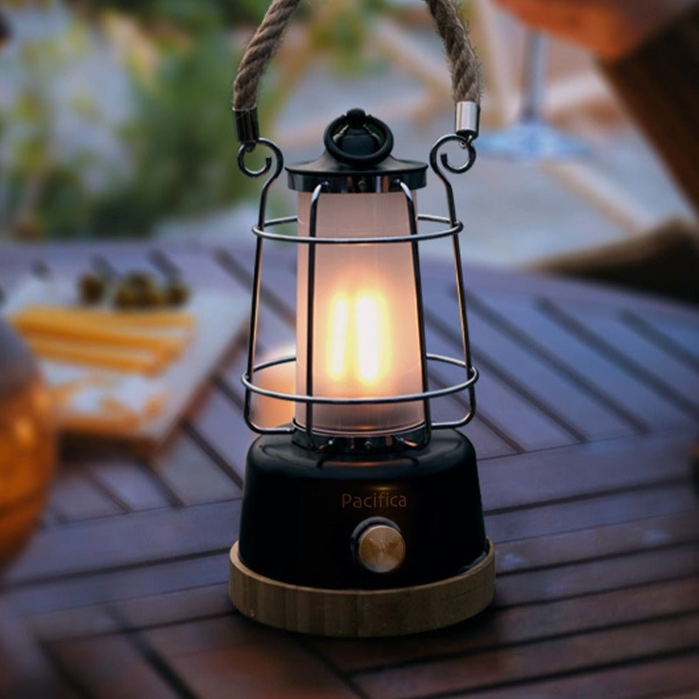 Mactronic Pacifica allumée, lumière chaude, sur une table de jardin en bois dehors