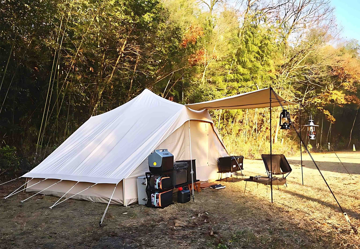 CanvasCamp Roman Traveller sur un emplacement en forêt avec auvent et matériel de camping