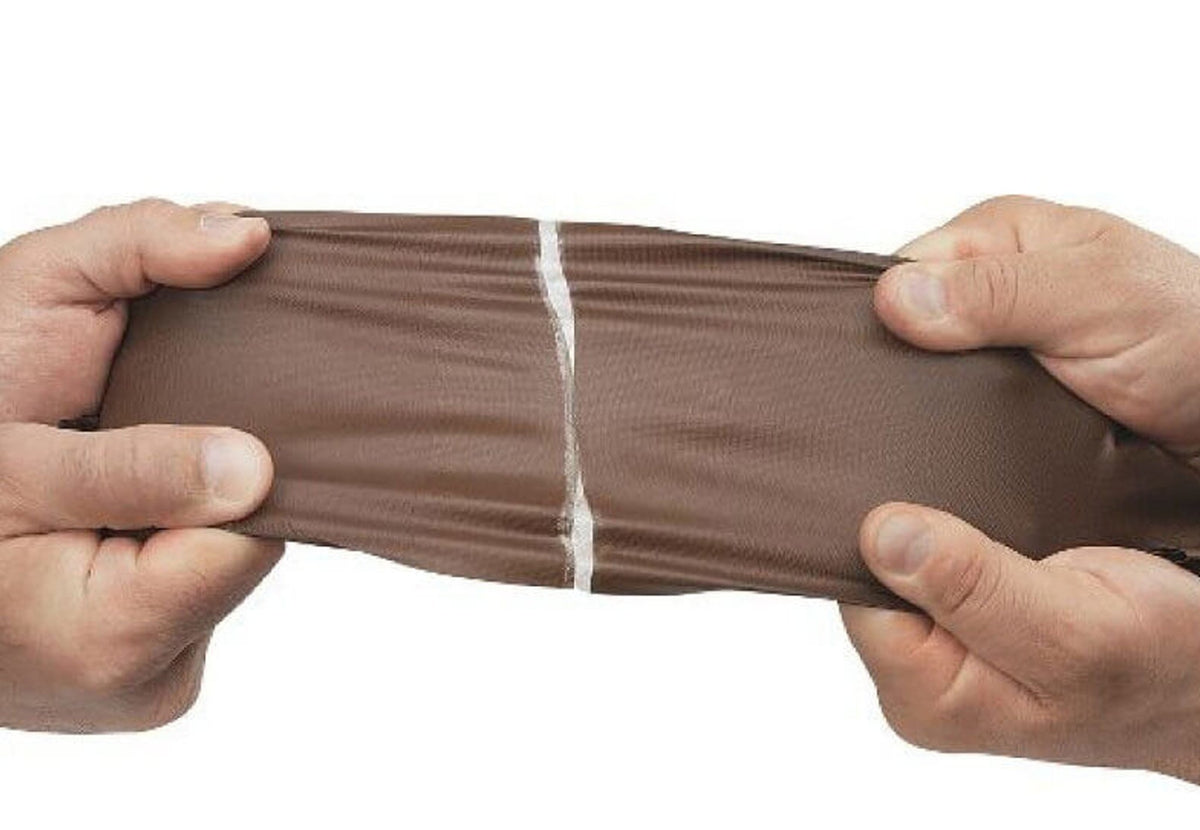 Réparation Tear-Aid B sur un matériau brun étiré à deux mains