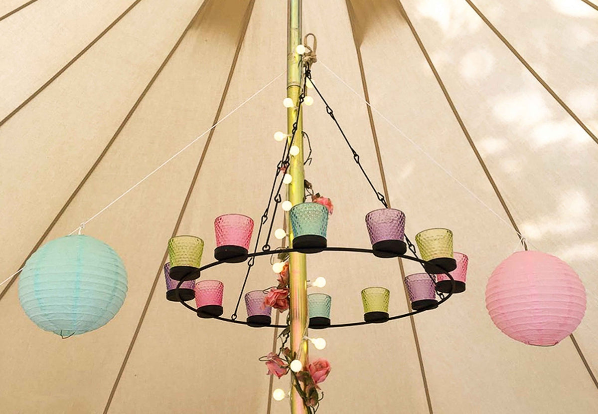 Lustre à bougies CanvasCamp au mât central d'une tente cloche avec verres colorés et lanternes