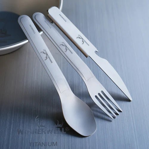 Winnerwell Titanium Cutlery Set avec cuillère, fourchette et couteau appuyés contre un bol sur une table