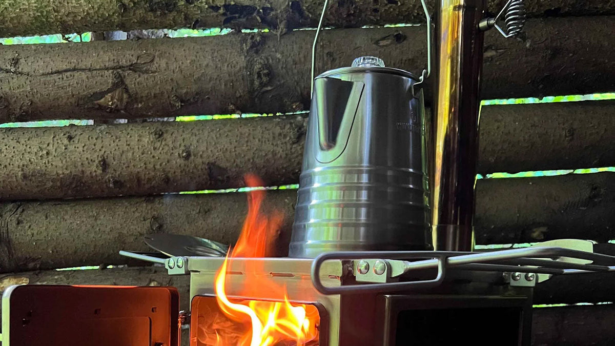 Percolators, stalen percolator op een kachel met open vuur in een hut van boomstammen