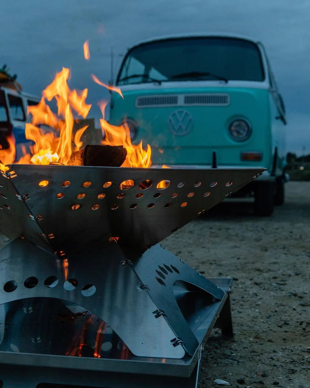 Foyer extérieur Winnerwell Flat avec de hautes flammes devant un combi Volkswagen vert clair