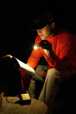 WakaWaka Connect Pro comme liseuse dans le noir, un homme lit un livre à sa lumière