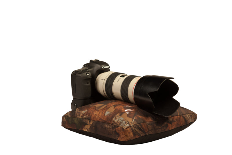 Buteo Photo Gear Bean Bag 3, coussin plat en camouflage feuillage avec un appareil photo et un téléobjectif