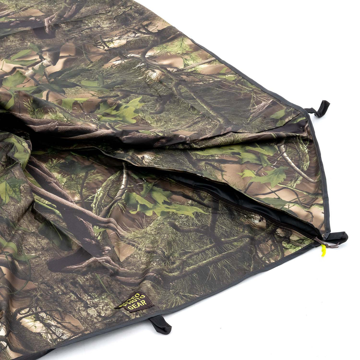 Housse de pluie Buteo Falco Mark IV en camouflage feuillage vert, détail du bord avec boucles et étiquette logo