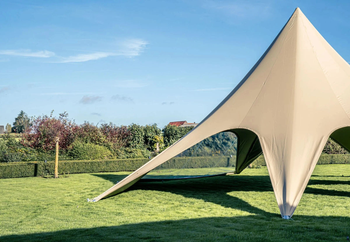 tente événementielle StarShade Pro taupe sur une pelouse sous un ciel bleu, vue latérale