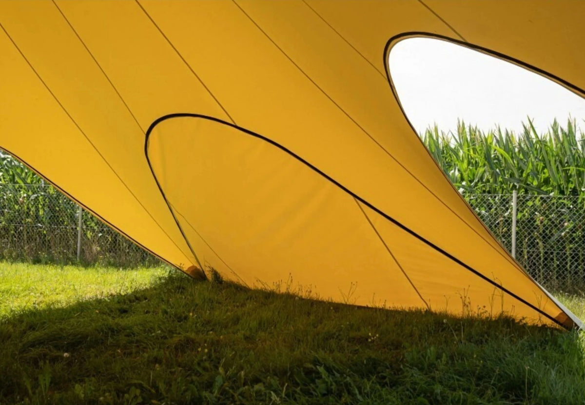 Paroi latérale fermée CanvasCamp StarShade Pro jaune, vue de l'intérieur près d'un champ de maïs