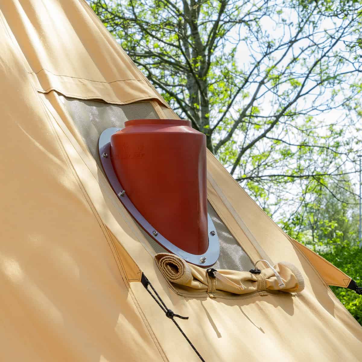 Winnerwell Arctic avec sortie de poêle inclinée rouge dans la paroi, sous les arbres