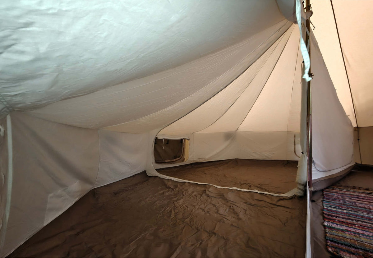Tente intérieure CanvasCamp Sibley en usage, vue le long de la paroi intérieure avec une petite fenêtre