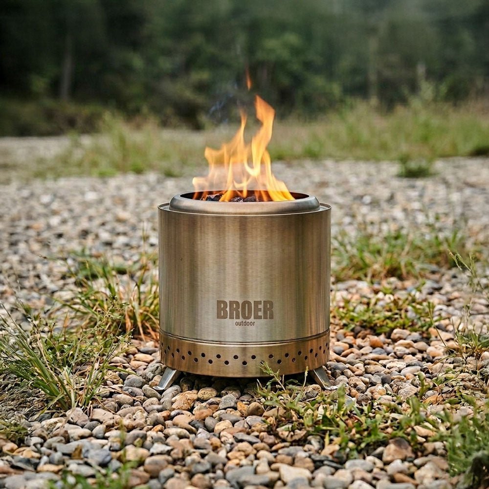 Foyer Broer Outdoor Vortex avec un feu allumé sur une étendue de gravier en pleine nature