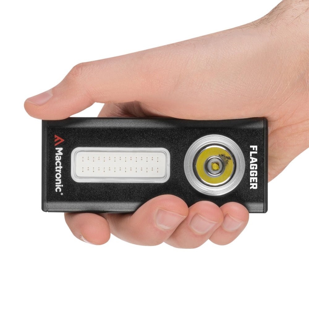 Mactronic Flagger posée dans une main, avec le panneau LED et la lampe ronde à l'avant
