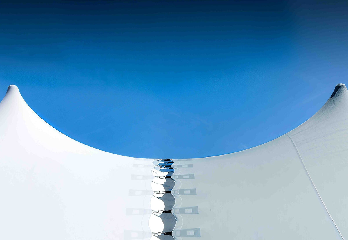 gouttière pour Stretch Tent Q2/Q3 reliant deux tentes stretch blanches sous un ciel bleu