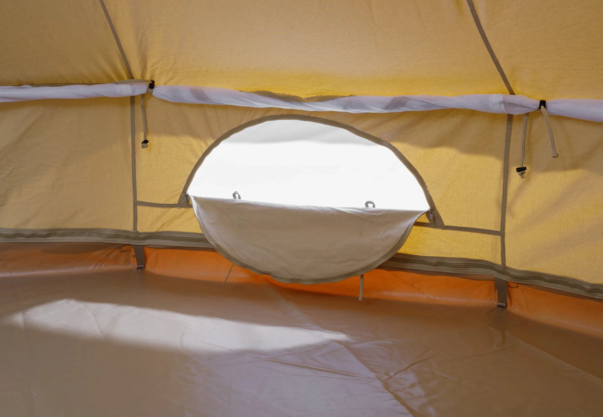 CanvasCamp Sibley ProTech 450 vue de l'intérieur, fenêtre ronde dans la paroi au-dessus du tapis de sol