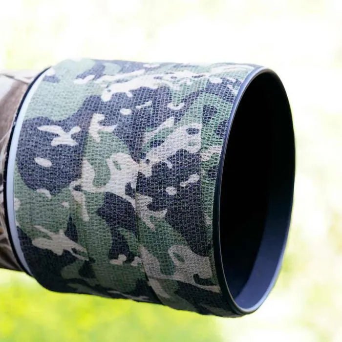 Bande camouflage Stealth Gear enroulée autour de l'avant d'un objectif, dehors dans la verdure