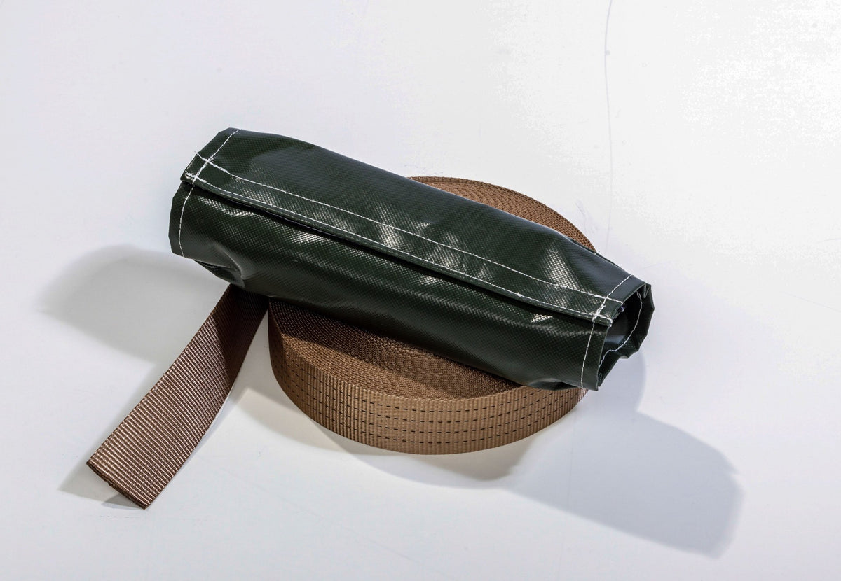 Sangle anti-tempête CanvasCamp, sangle brune enroulée avec une housse de protection foncée