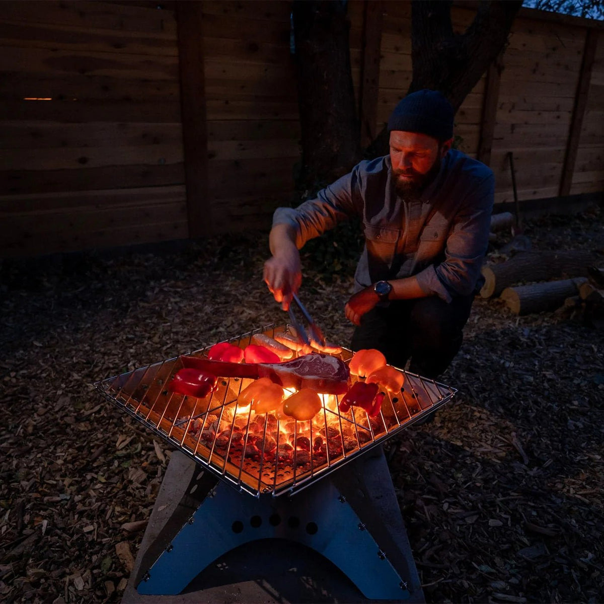 Grille de cuisson Winnerwell sur un foyer plat allumé avec viande et légumes le soir