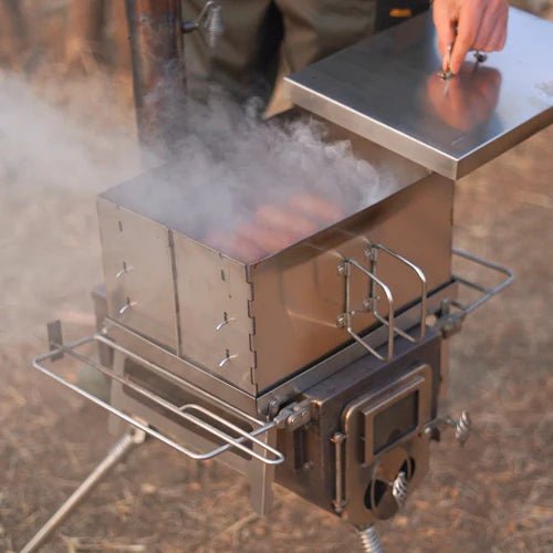 Winnerwell Flat Smoker utilisé sur un poêle, avec fumée et saucisses sous le couvercle soulevé