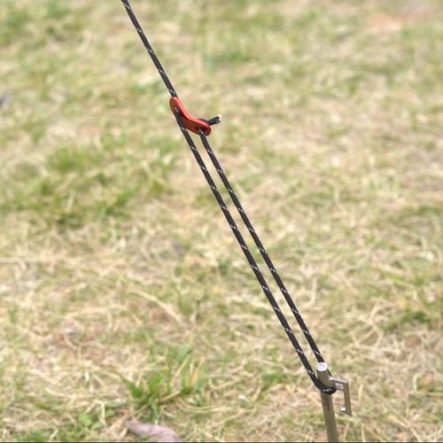 Winnerwell Guyline Peg Set, hauban avec tendeur rouge sur une sardine dans l'herbe