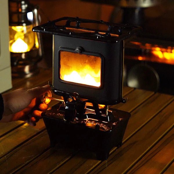 Winnerwell Iron Camping Cooker Stove allumé sur une table en bois, flammes derrière la fenêtre