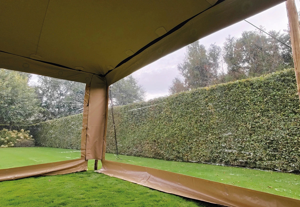 paroi latérale pour Stretch Tent Q2/Q3 vue de l'intérieur, donnant sur un jardin avec une haie